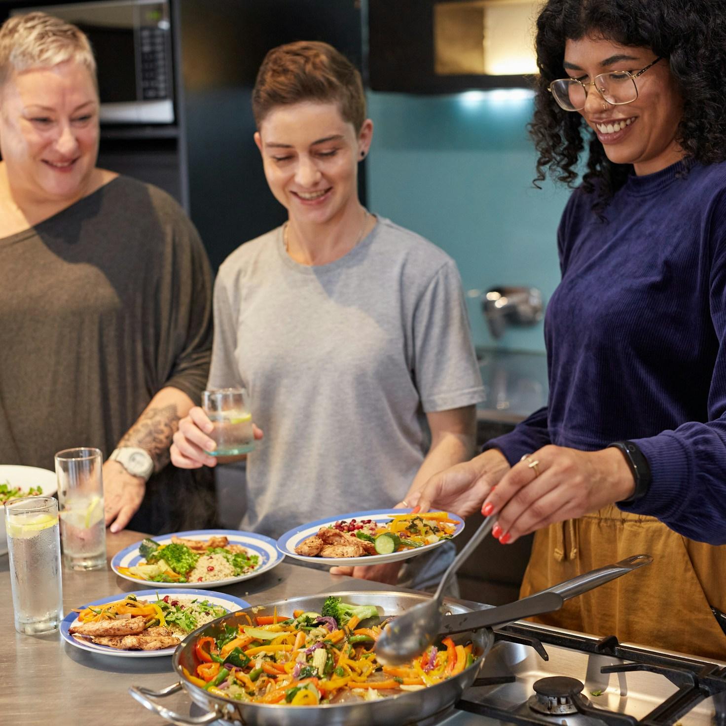 Community members collaborating in a modern kitchen space, sharing recipes and cooking techniques